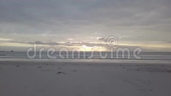 海滩上神奇的日落光束透过云层照射在海景上快速飞行4k30fps视频的预览图