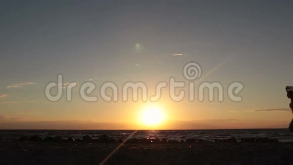 日落时分一个带着飞围巾在沙滩上奔跑的女人视频的预览图