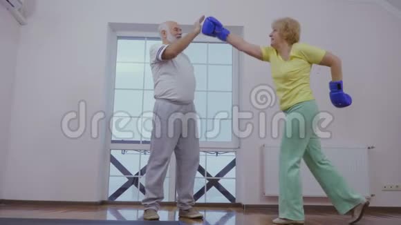 戴拳击手套的老妇人和丈夫一起训练视频的预览图