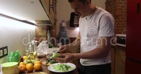 年轻人在厨房里切蔬菜视频的预览图