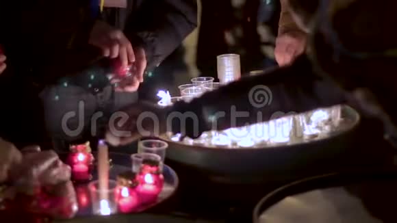 一群人用塑料眼镜点燃几十支蜡烛晚上很亮视频的预览图