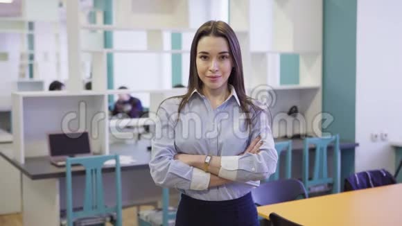 自信的商务女性站在办公室里双臂交叉视频的预览图
