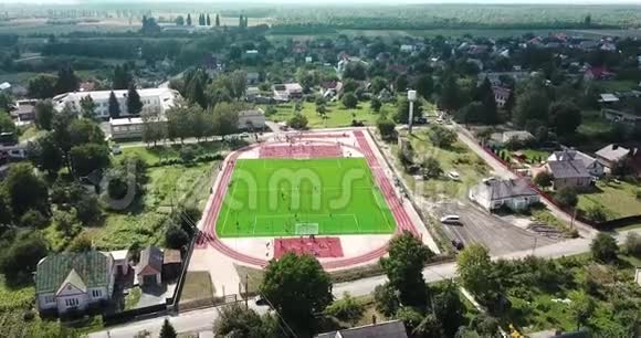空旷的运动场在村里鸟瞰打大网球的红色运动场视频的预览图
