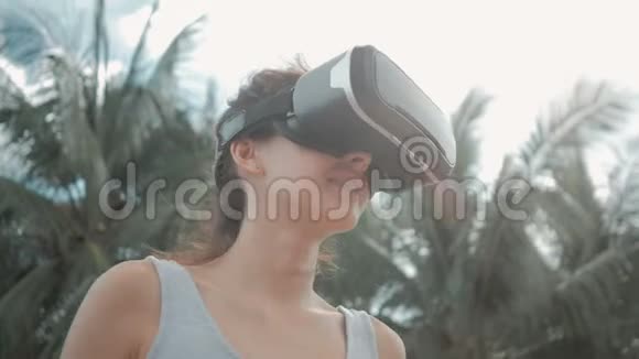 快乐的年轻女子戴着虚拟现实耳机跳舞视频的预览图
