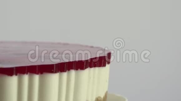 蛋糕表面有草莓和樱桃的光泽瓷盘上的甜点在一个瓷盘里旋转视频的预览图