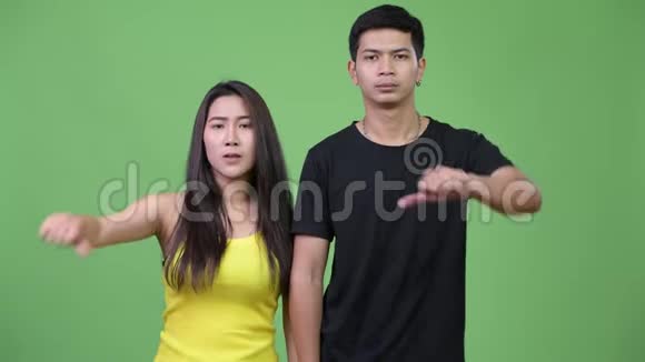 年轻悲伤的亚洲夫妇一起竖起大拇指视频的预览图