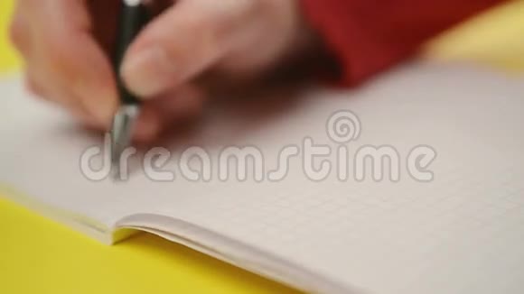 女人在笔记本上写笔记关闭稳定的镜头有选择地集中在手上视频的预览图