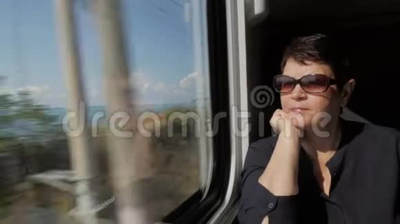 火车窗口附近戴墨镜的老年妇女视频的预览图
