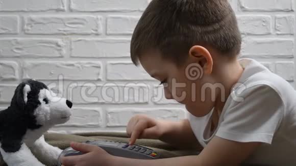 坐在地板上按pos终端按钮的小男孩孩子们的现代技术pos机练习儿童视频的预览图