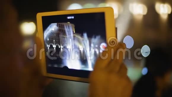 旅游者用便携式设备拍摄视频音乐喷泉画面出现在屏幕上视频的预览图