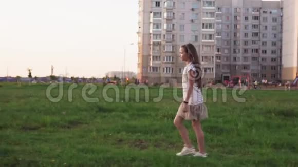 可爱的小女孩在城市草坪上的草地上散步视频的预览图