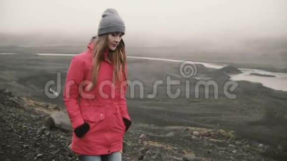 年轻迷人的女人独自走在火山黑山里游客探索冰岛去冰湖视频的预览图