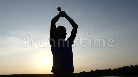 年轻人举起冠军杯在日落时微笑视频的预览图