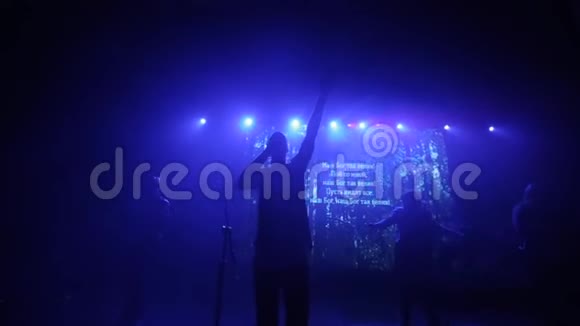 蓝光一个举起手在舞台上唱歌的人音乐会上的音乐团体视力模糊视频的预览图