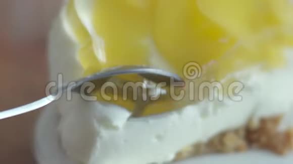 甜点汤匙掰下一块桃子芝士蛋糕精致的奶油桃子蛋糕留在瓷盘上A视频的预览图