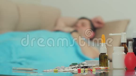 一个有疾病症状的成年男子在毯子盖下睡在沙发上视频的预览图