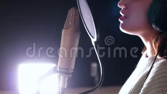 一位年轻迷人的女子在录音室唱歌视频的预览图