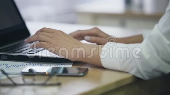 办公室女员工手在笔记本电脑上打字在电子文档中插入数据视频的预览图