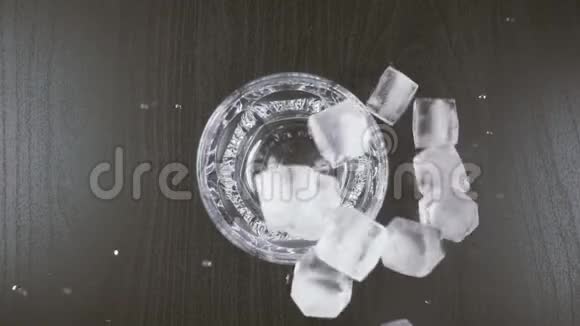 冰从上面落在玻璃和桌子上视频的预览图