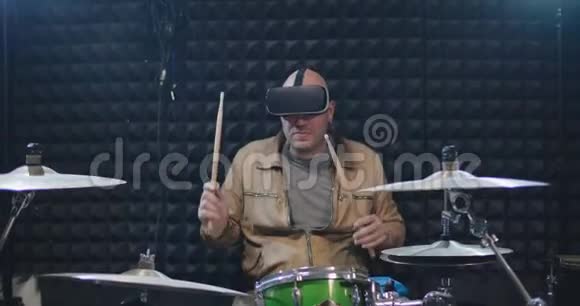 音乐家戴着虚拟现实头盔和打鼓的肖像视频的预览图