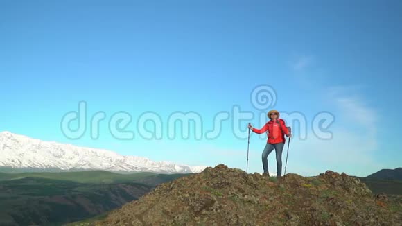 旅行者的女人在岩石上花费看着雪山慢镜头视频的预览图