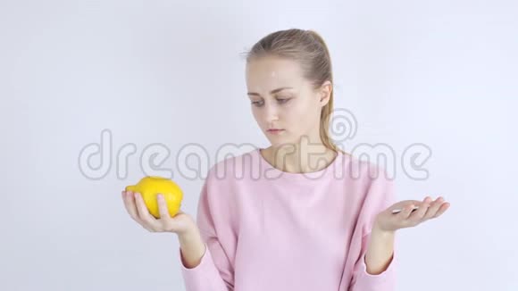 年轻女子在柠檬和药丸之间选择视频的预览图