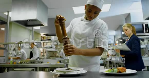 厨师在4k餐厅厨房使用胡椒粉视频的预览图