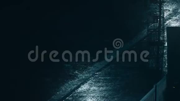 一场大雨在夜间落在人行道上视频的预览图