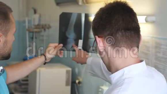 两位男医生观看mri图片并讨论这个问题医院里的医务人员检查和分析X光视频的预览图