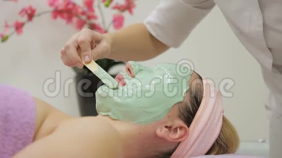 化妆师把绿色面具戴在女人脸上厚厚的一层视频的预览图
