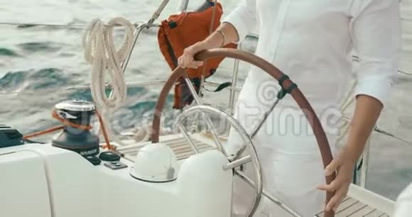 在游艇上的船长穿着白色衣服的长胡子帅哥双手握在游艇上的方向盘上视频的预览图