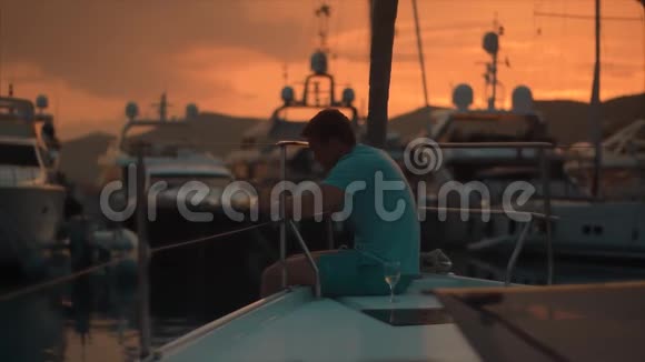 夕阳西下的帆船上悲伤的帅哥视频的预览图