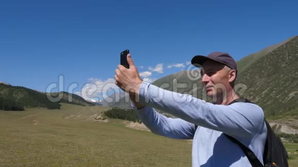 用手机拍照的人在山上美丽的风景视频的预览图