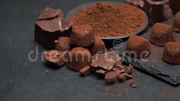 黑色混凝土背景下的经典巧克力松露和巧克力片视频的预览图
