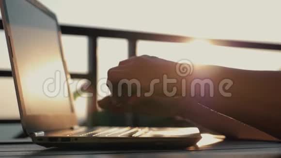 一个女人在工作场所用笔记本电脑打字夕阳下的女孩电子网上购物视频的预览图
