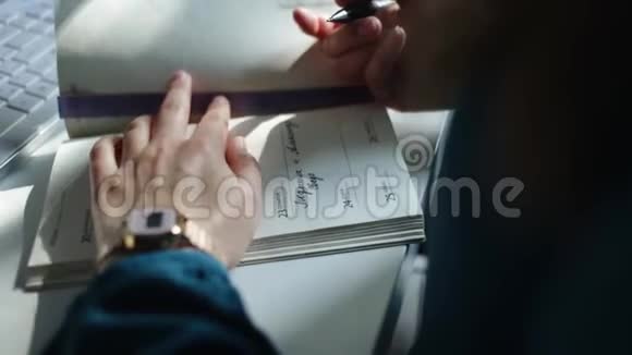 一个女孩在笔记本上写纸条的特写镜头纸条放在靠近白色键盘的白色桌子上视频的预览图