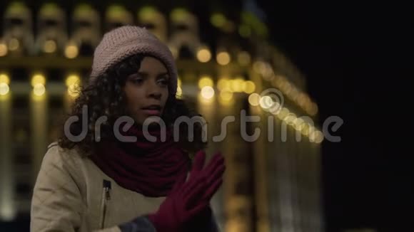 冻僵的女孩在夜城街道等待出租车美丽的女士迟到约会视频的预览图
