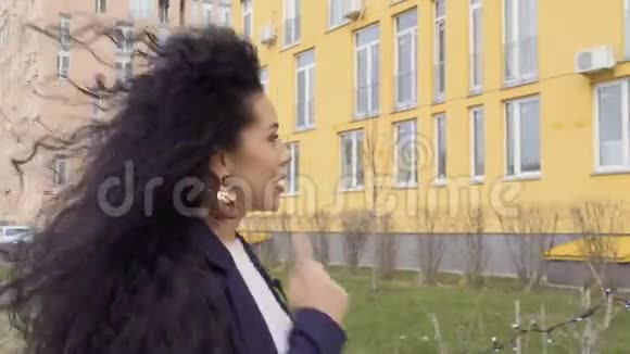 美丽的黑发记者与镜头交谈走在街上视频的预览图