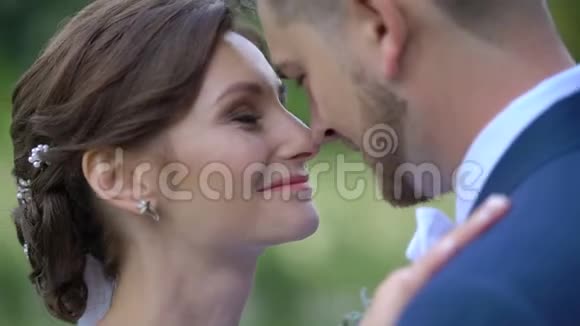 特写敏感的肖像令人惊叹的新婚夫妇在情人轻轻摩擦鼻子视频的预览图