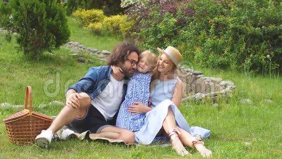 幸福的家庭和他们可爱的女儿蓝色的衣服戴帽子的女人在户外野餐视频的预览图