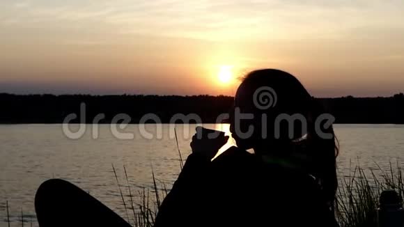 年轻女子躺在湖边喝着茶笑着视频的预览图