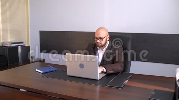 上班族在电脑上打字报告在办公室里用手提电脑工作的商人视频的预览图