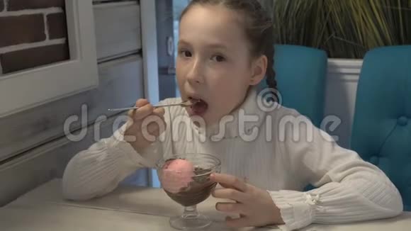 一个满脸雀斑的小女孩坐在咖啡馆里吃冰淇淋视频的预览图