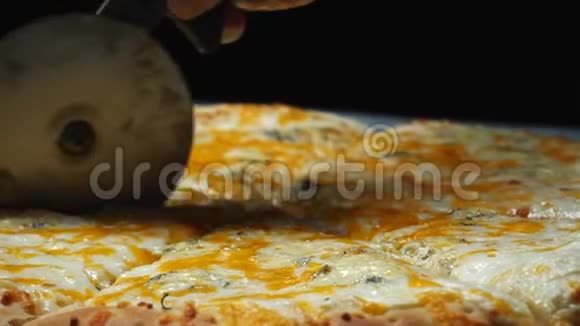 提供美味的四个奶酪披萨和厨师并在桌上的木板上切割披萨片视频的预览图