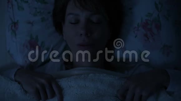 一个女孩晚上躺在床上看着天花板睡不着从上面看视频的预览图