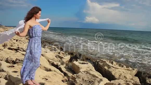 美丽的女模特在岩石海岸拍照风暴开始了视频的预览图