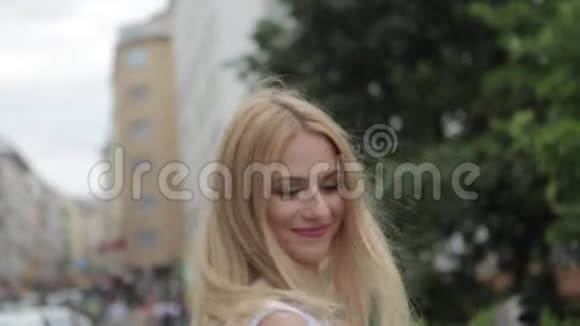美丽的金发女人穿着白色连衣裙在市中心跳舞视频的预览图