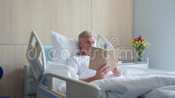 多莉在医院里拍摄了一个有思想的老人在看书视频的预览图