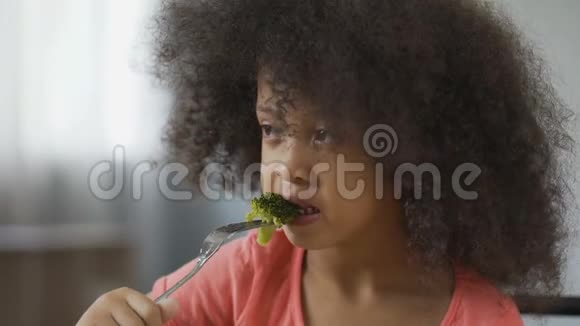 有趣的非洲裔美国女孩吃花椰菜厌恶健康的食物节食视频的预览图