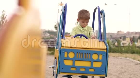 一个小男孩坐在操场上的车上视频的预览图